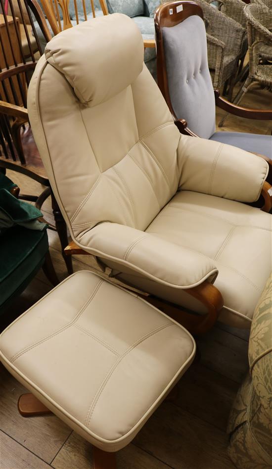 A modern white leather swivel armchair and matching stool